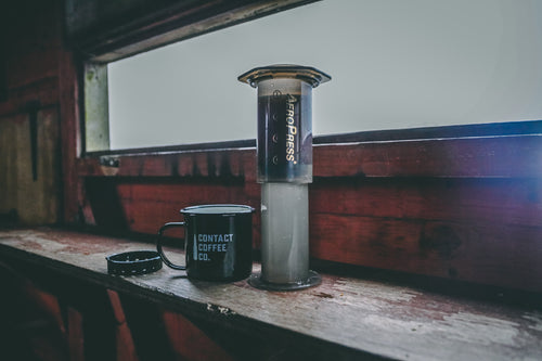 contact coffee co mug with a travel coffee maker outdoors