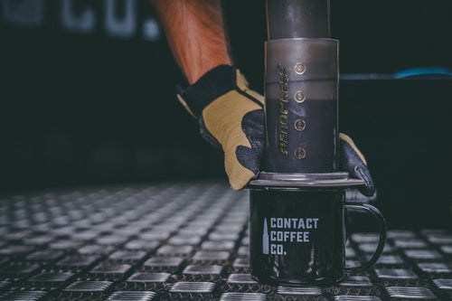 military man pressing portable coffee maker
