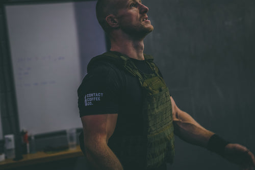 man in weighted vest wearing contact coffee co t-shirt