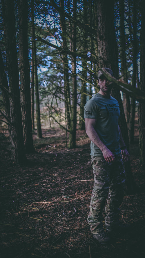 man outdoors in green military t-shirt in multicam trousers