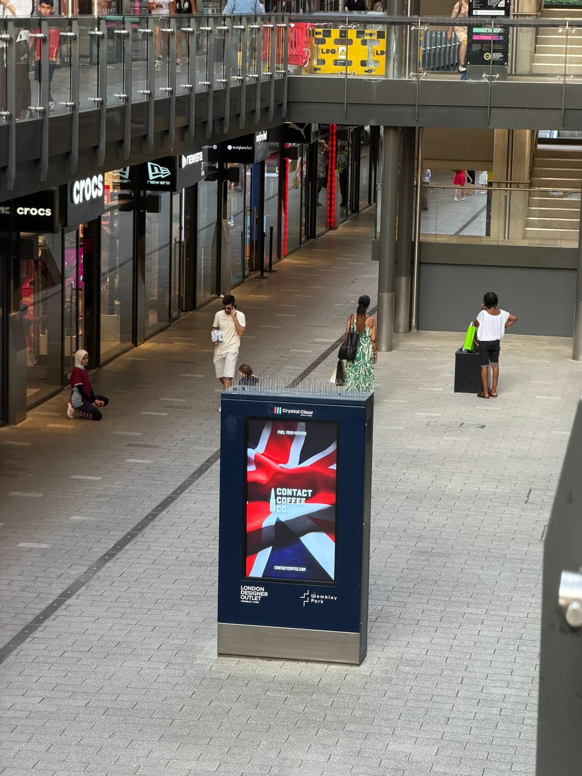 Contact Coffee Union Jack campaign on a digital screen at London Designer Outlet, Wembley Park, with the Wembley Stadium arch behind