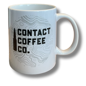 White mug with Contact Coffee bullet logo and topographical lines