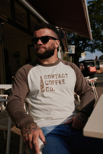 Contact Coffee Baseball Long Sleeve, Cement / Clay - seated outside