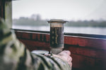  camouflage jacket with portable aeropress coffee maker outside