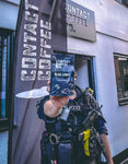policeman holding contact coffee co coffee bag